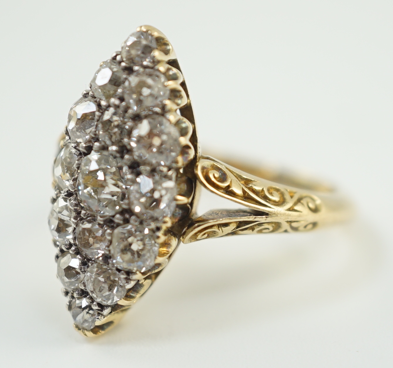 An early to mid 20th century 18ct gold and fifteen stone diamond cluster set marquise shaped ring